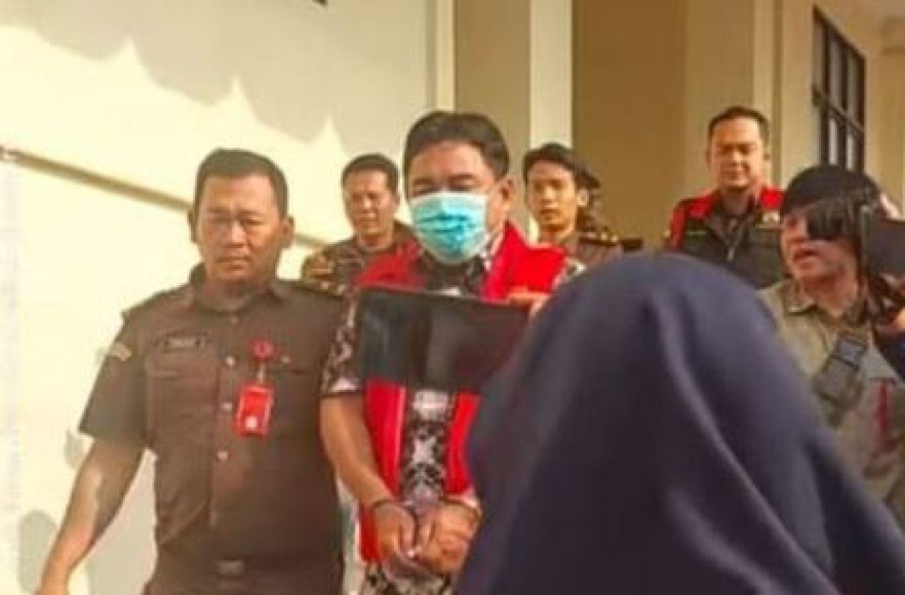 Anam Warsito mengenakan rompi merah
