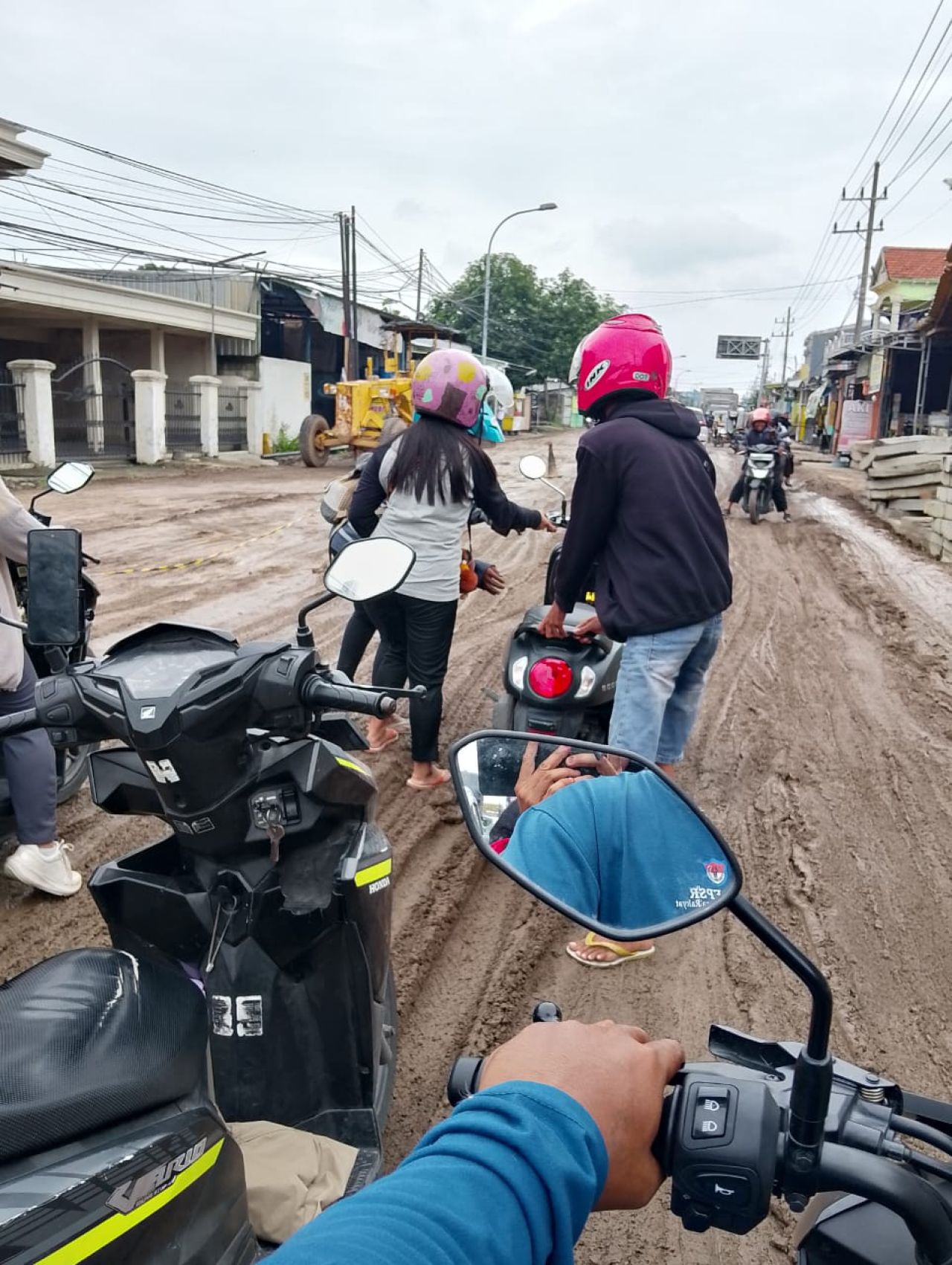 Seorang pengendara jatuh dibantu pengendara lain