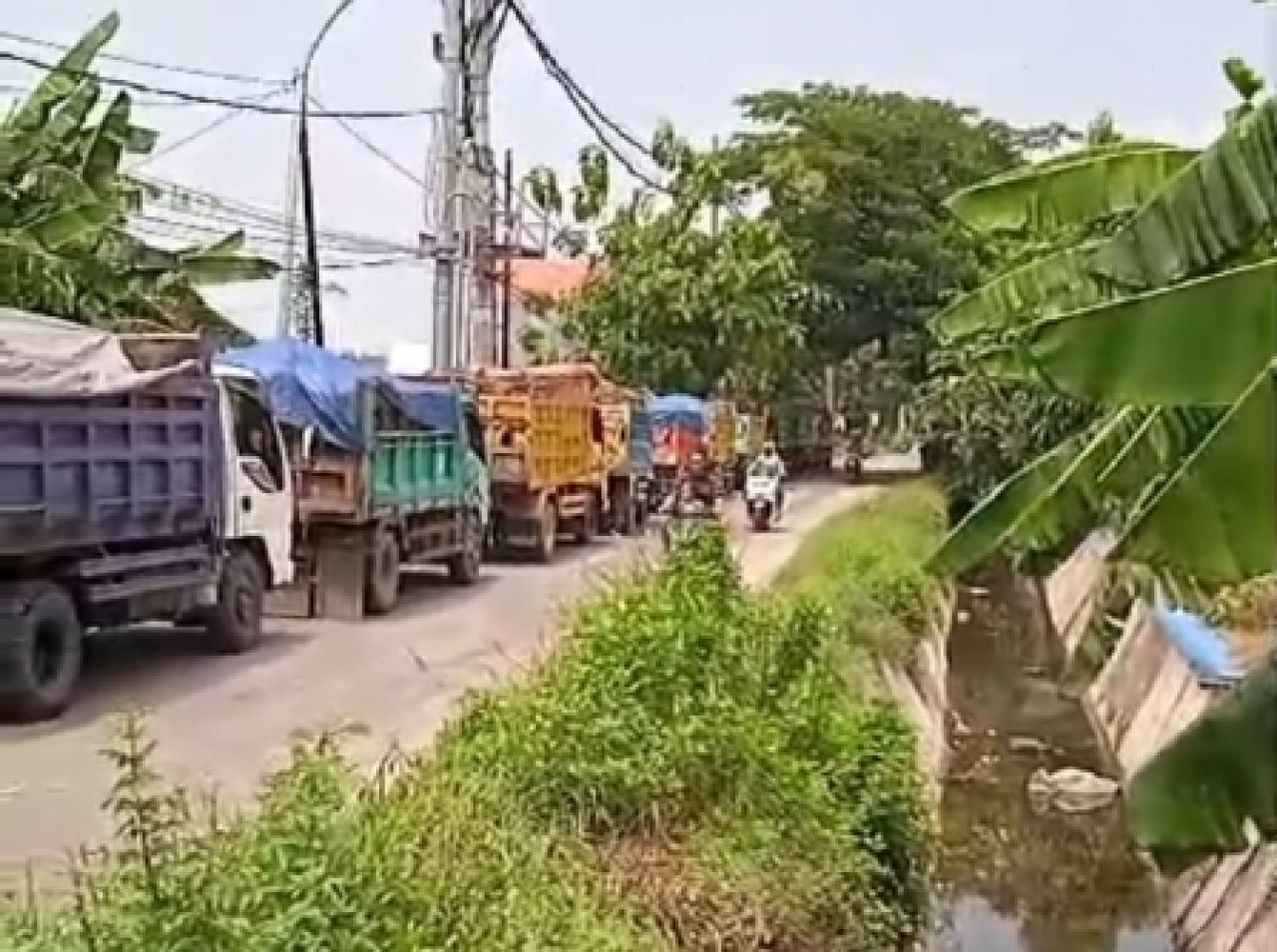 Beberapa truk antri bongkar tanah urug