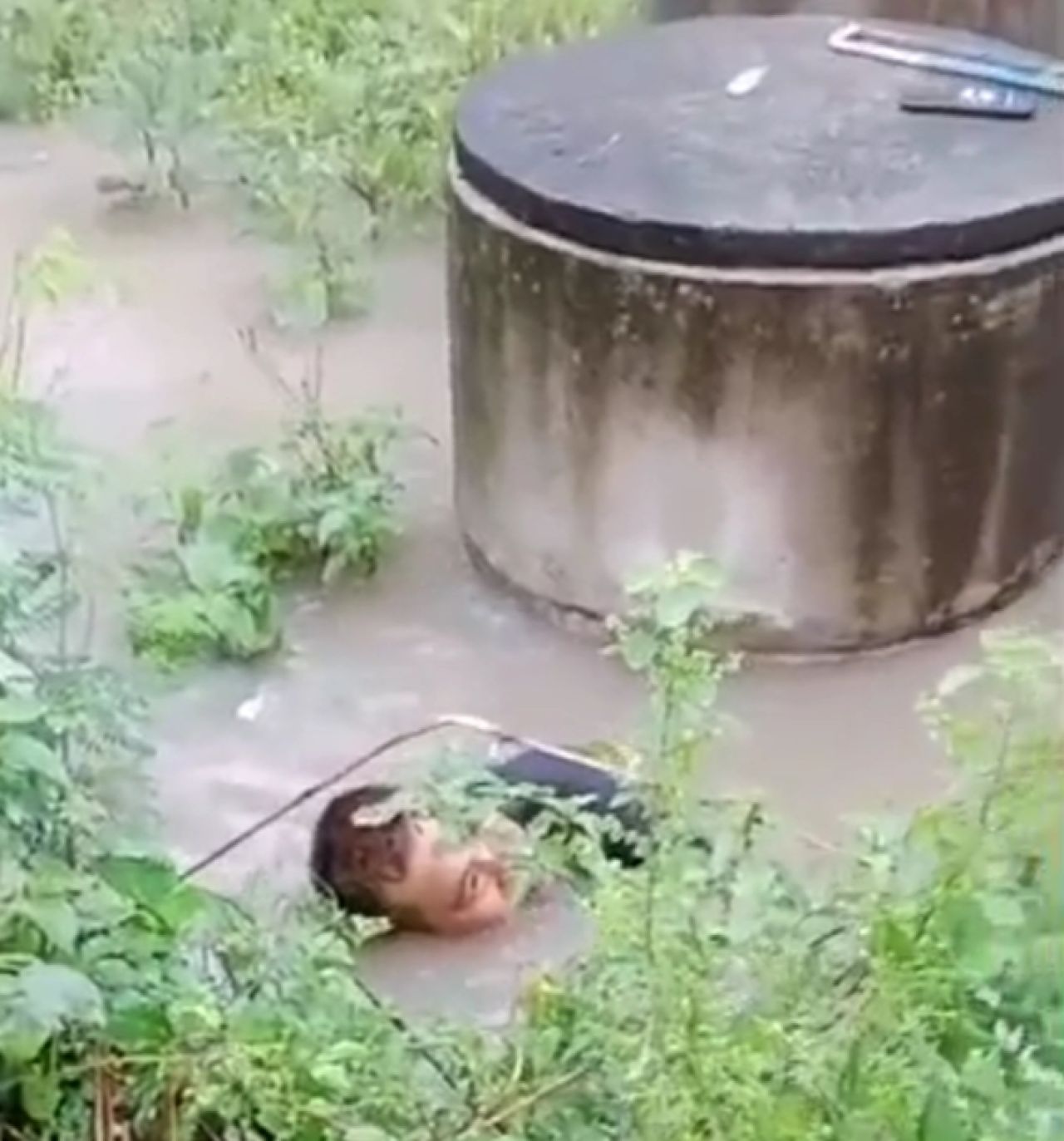 Ketua RT di Desa Driyorejo sedang membersihkan sampah di gorong-gorong