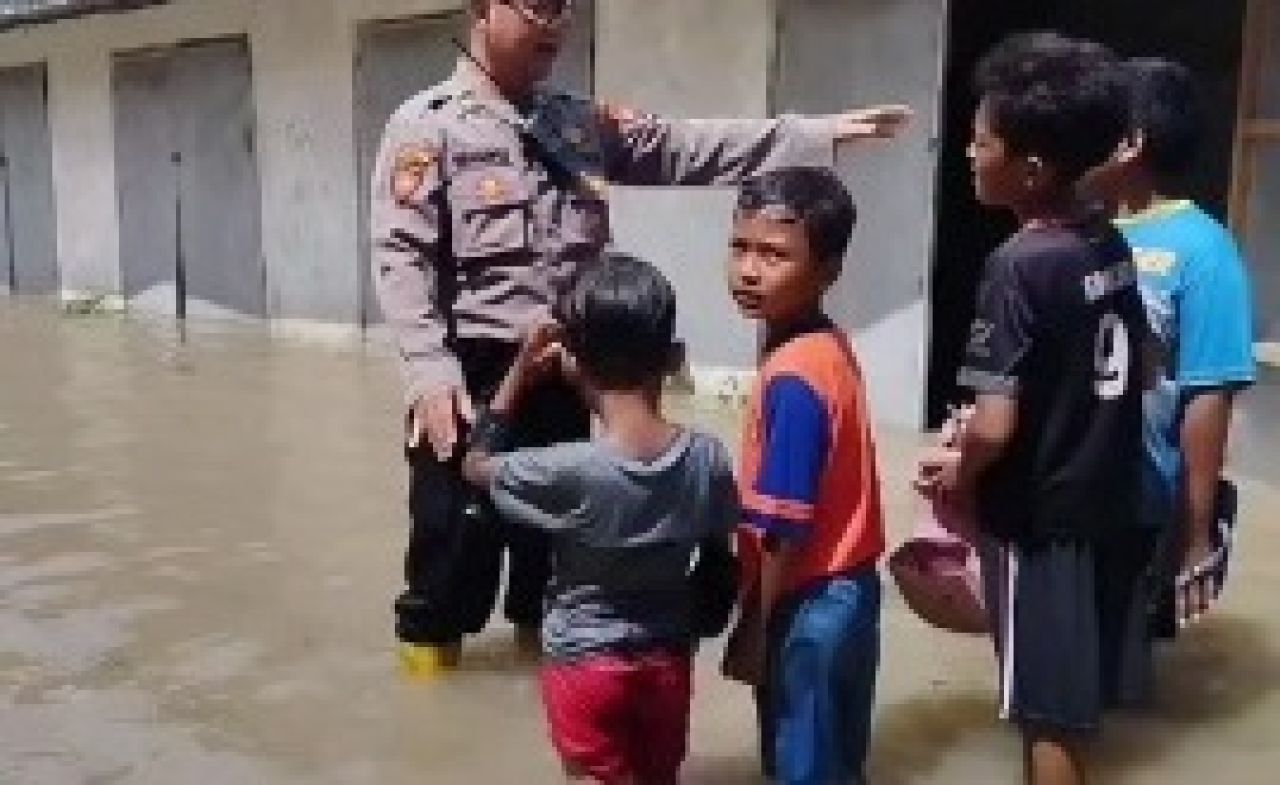 Aiptu Wahyu bertemu dengan anak-anak sedang bermain air di tengah banjir