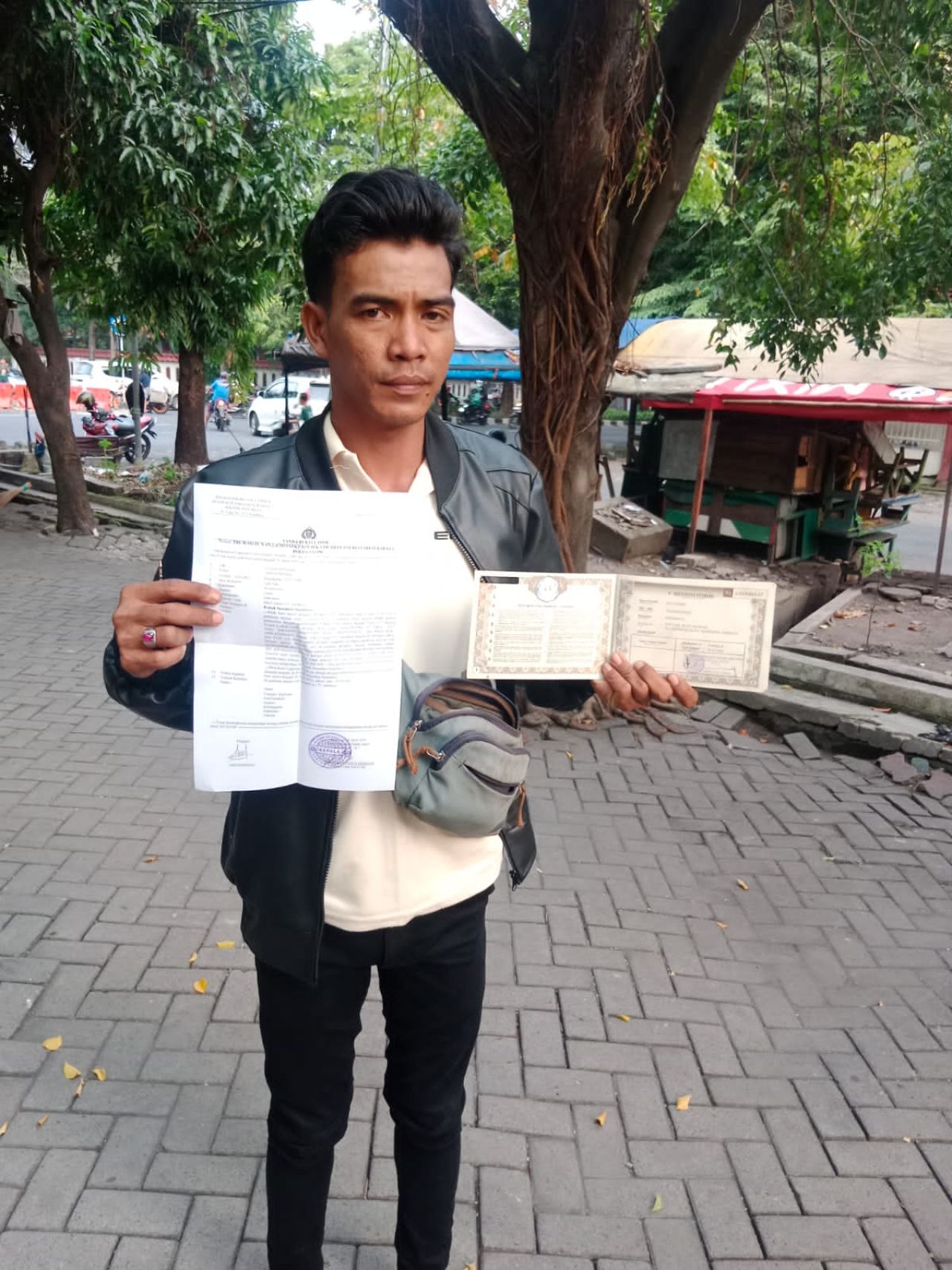 Abdur Rohman menunjukkan bukti lapor ke Polisi dan surat kendaraan yang dicuri