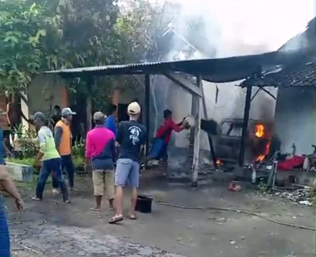 Warga berupaya memadamkan api yang membakar mobil milik Ali