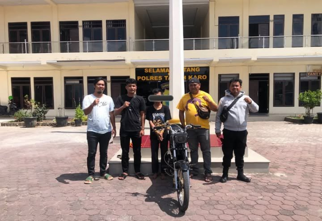 Tersangka pencurian motor (tengah) bersama petugas Polres Tanah Karo