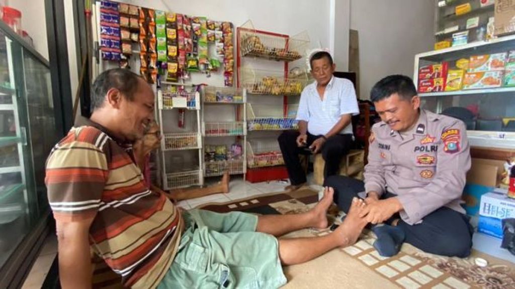 Aipda Dasmer saat mengobati warga