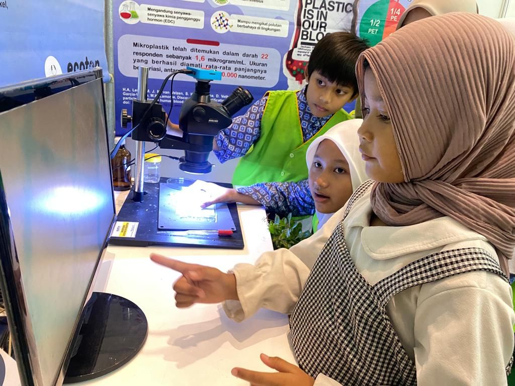 Seorang pengunjung stand Ecoton melihat bahaya plastik