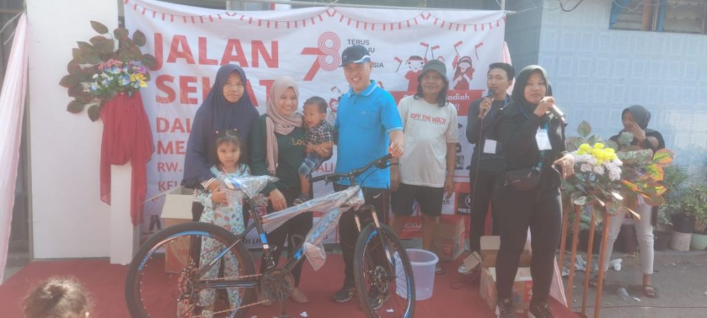 Moch. Harun menyerahkan sepeda kepada peserta yang dapat undian