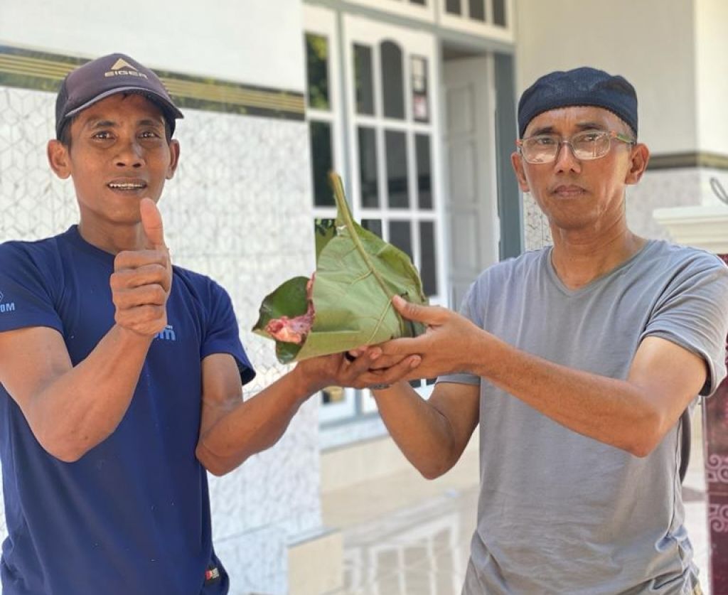 Panitia kurban SDIT AL-HUDA menyerahkan daging kurban berbungkus daun jati
