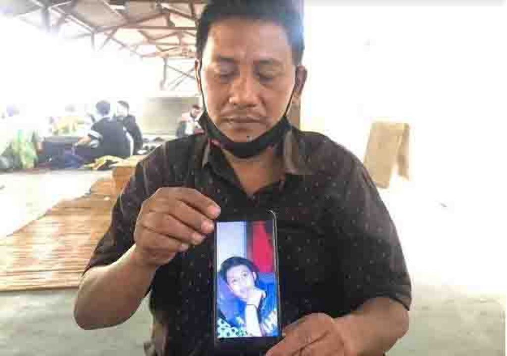 Sujadi menunjukkan foto anaknya dari layar HP